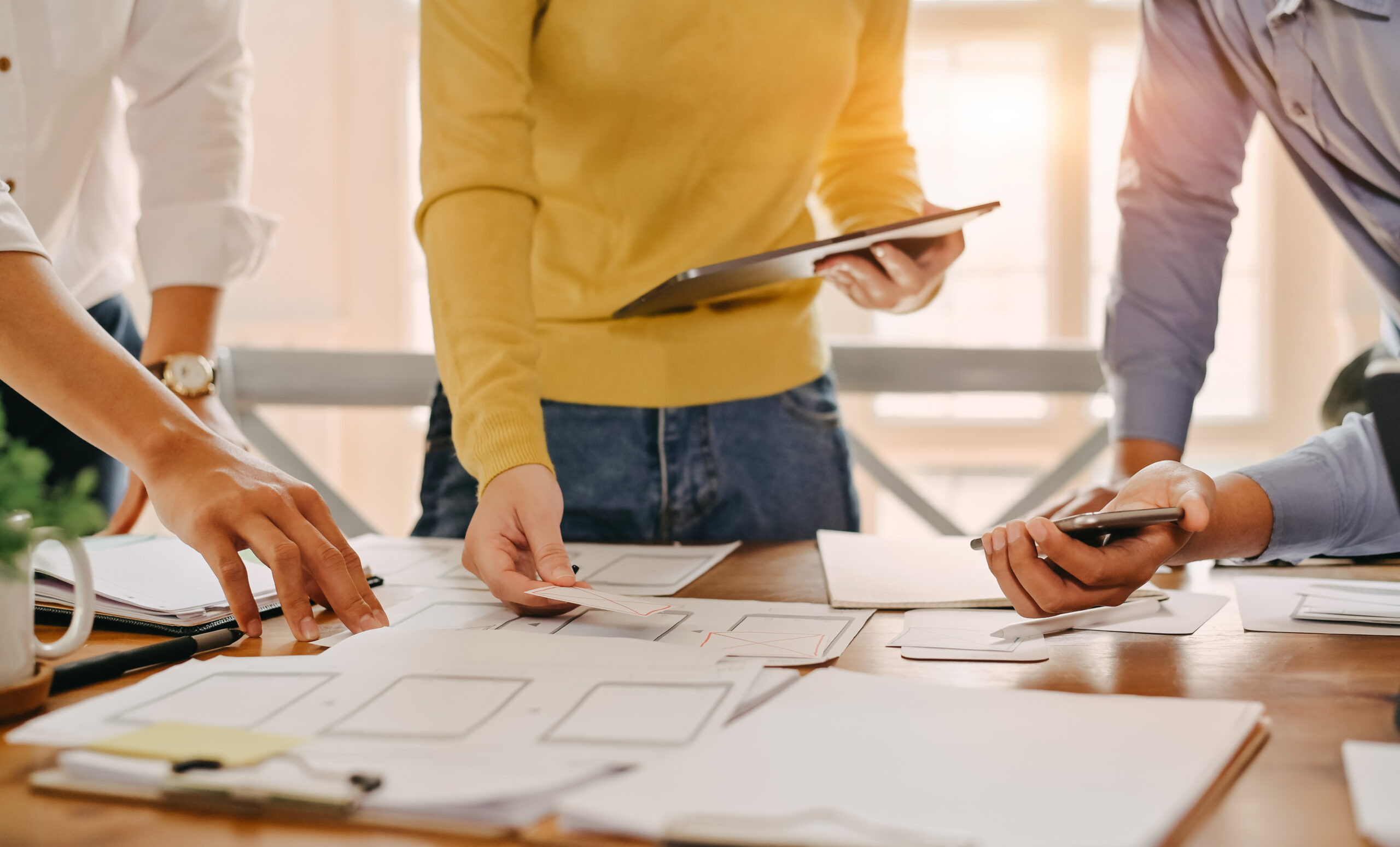 A team holding pieces of paper and brainstorming about brand development