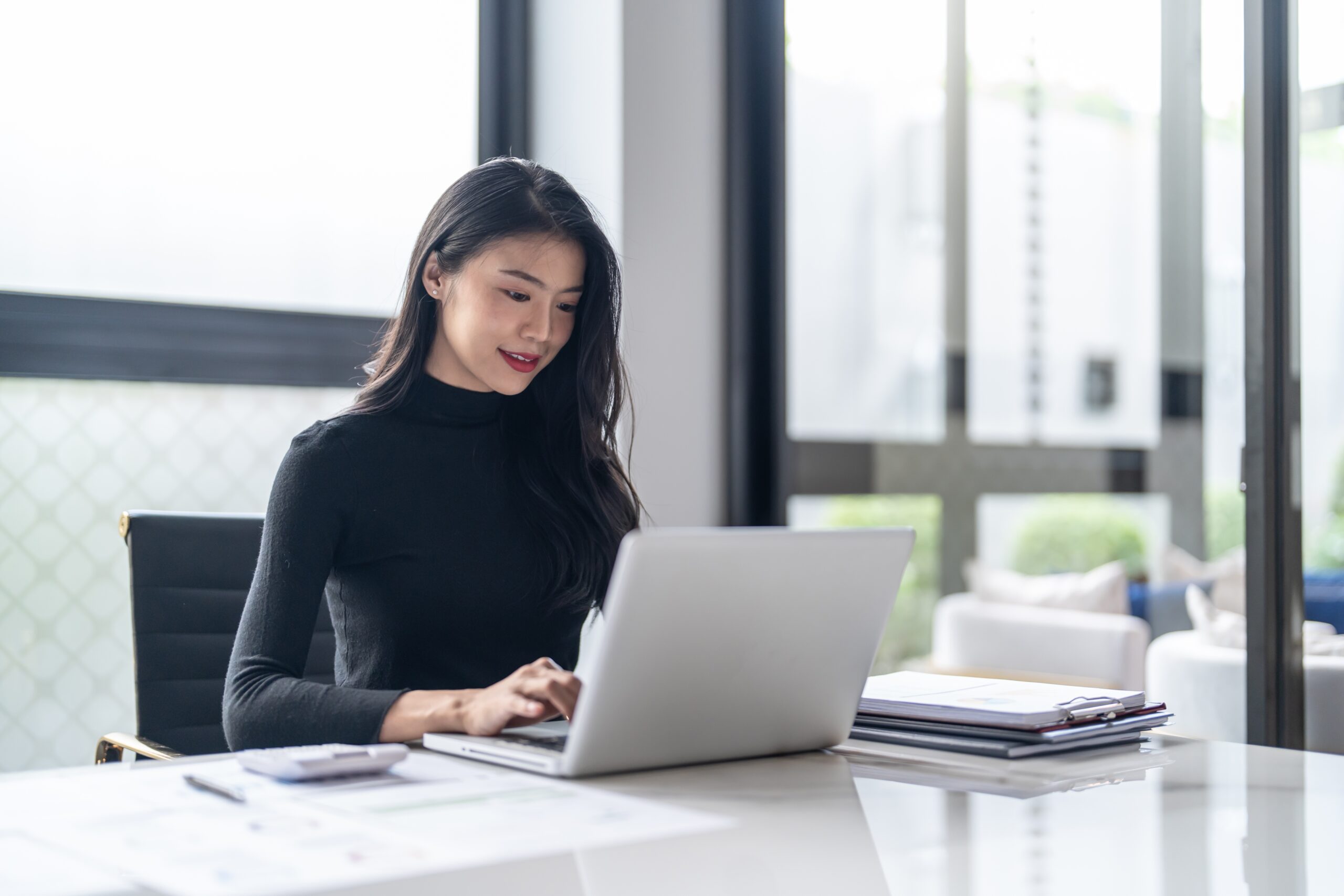 Professional young woman typing on a laptop during her full-time job